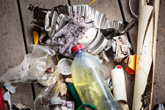 Mixed plastic and fabric waste on the beach, flotsam, pollution, litter.