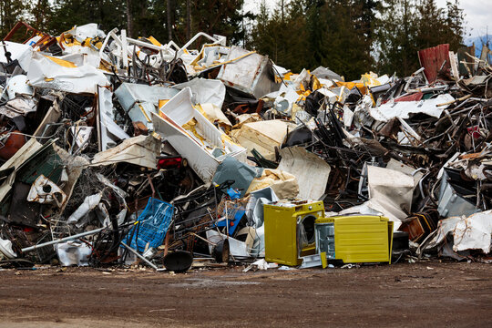 Large pile of washing machines, refrigerators and metal heap in a recycling plant, white goods.