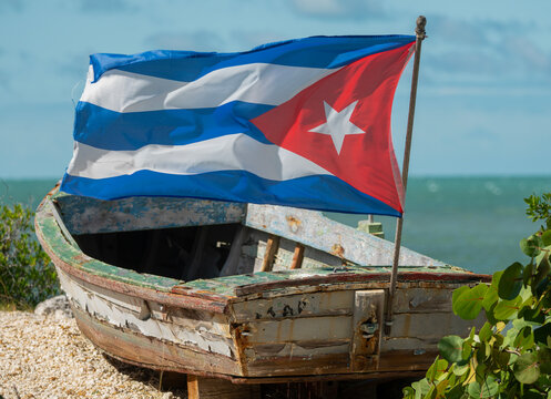 Weathered Cuban Refugee Boat with Flying Cuba Flag on Florida Coastline
