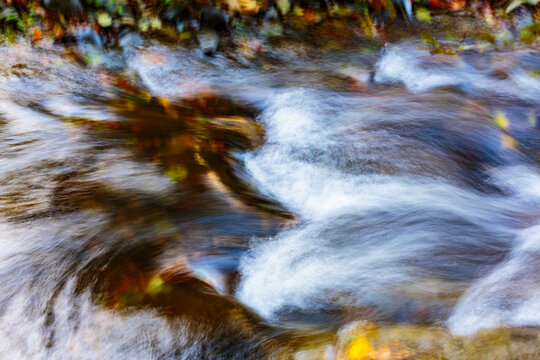 Flowing water, motion blur, long exposure of the surface of moving water in a river.