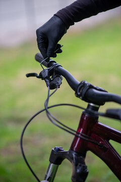 Gloved Hand Adjusting Bicycle Brake Cable on Handlebars