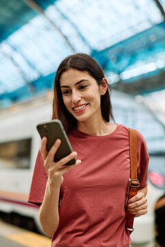 Young Woman Using Phone In A Subway Station