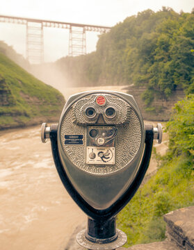 A lookout point with binoculars at Upper Falls with the Genesee Arch Bridge, in the Letchworth State Park.
