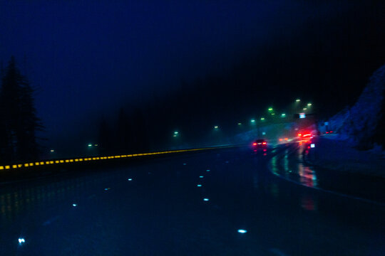 Night driving, limited visibility in the darkness, the wet road surface of Interstate 90 through the Cascade Mountains.