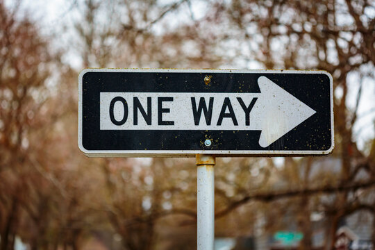 One Way sign on a metal pole, road sign with information, one way only, a restriction.