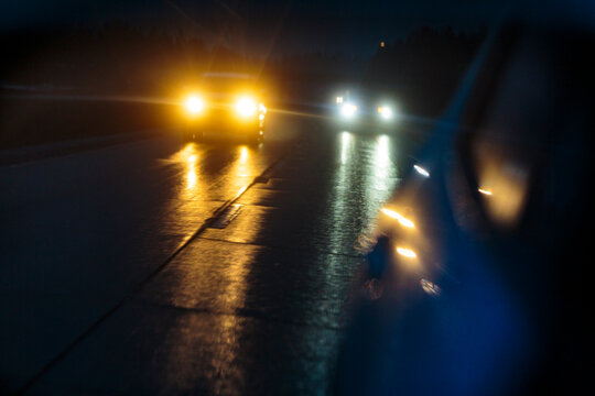 Side mirror reflection of car headlights in stormy weather on Interstate 90 in Washington State,