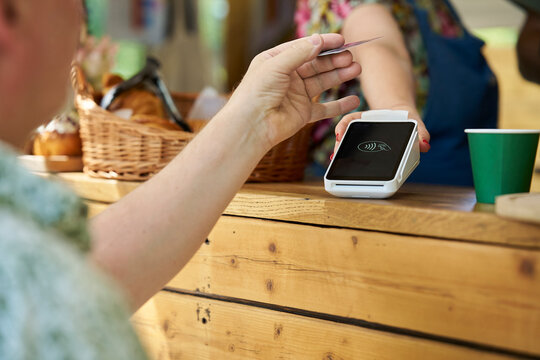 Close Up Of Person Making Contactless Payment For Takeaway Coffee