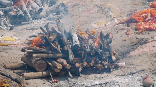 Traditional hindu funeral ceremony with a burning pyre on the banks of the river ganges in varanasi, an ancient indian spiritual ritual