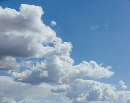 White cumulous clouds gathered in a blue sky.