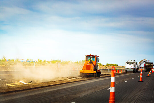 Highway construction along Interstate 90 from Vantage to George, resurfacing, a tarmac spreader and rolling machine..