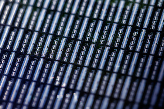 Macro detail of microchip grid on silicon wafer closeup background highlighting circuits and rows for technical