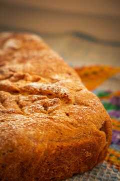 Fresh homemade loaf with a rich golden crust, delicate flour dusting, and ornamental radial scoring that creates an eye-catching geometric pattern