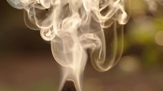 Close-up of curling smoke tendrils in outdoor setting
