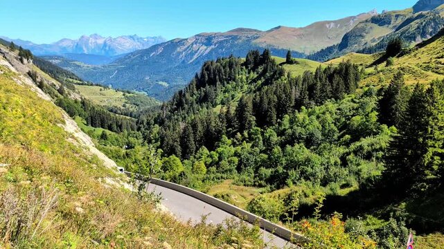 Small truck driving scenic asphalt mountain road on beautiful summer day. Commercial logistics transport vehicle delivers cargo along winding alpine route. 