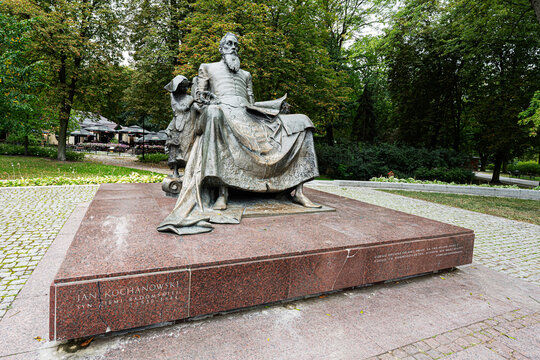 Statue of Jan Kochanowski seated in a leafy park at Radom, Poland, bronze memorial honoring the Renaissance poet