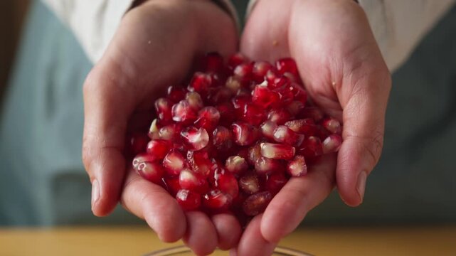 Hands Holding a Handful of Fresh Pomegranate Arils