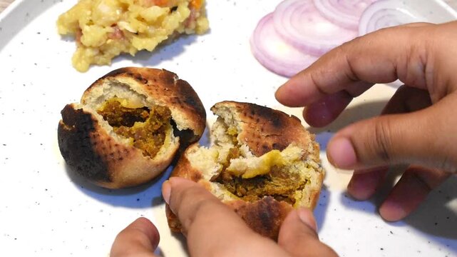 Breaking litti before putting ghee on it.