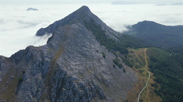Aerial view of thick clouds rolling over limestone peaks and green valleys in Urkiola Natural Park, Basque Country, Spain