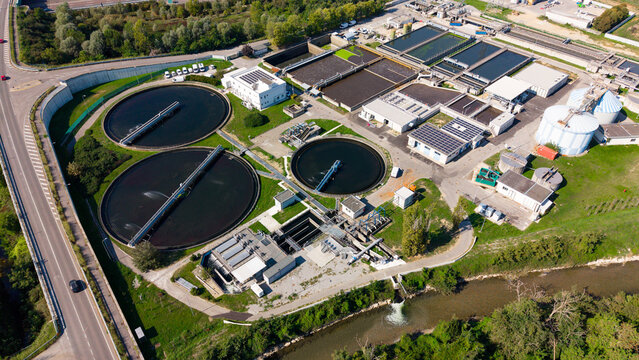 Aerial view of the Depuratore di Truccazzano wastewater treatment plant, featuring circular sedimentation tanks and rectangular basins in Truccazzano, Lombardia, Italy.