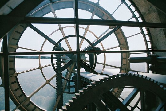 Close-up view of large clockwork gears inside a vintage clock tower with window view
