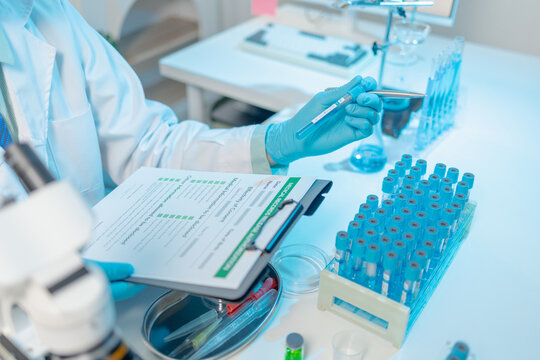 Scientist examining laboratory samples and test tubes for scientific research, analysis, and experimental studies in a modern laboratory.