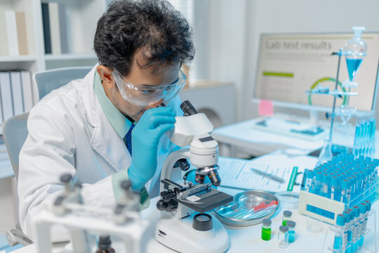 Scientist examining laboratory samples and test tubes for scientific research, analysis, and experimental studies in a modern laboratory.
