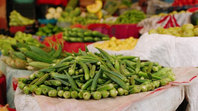 Fresh green okra and other vegetables selling at a vibrant indian street food market stall