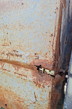 Rust on the car body, an old vehicle damaged by corrosion.