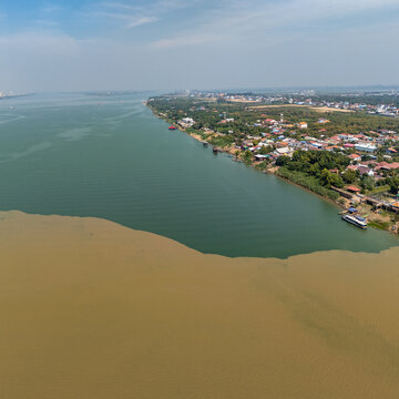Aerial view of the confluence of the Mekong and Tonle Sap rivers showing the contrast between the muddy and clear waters along the riverbank in Phnom Penh, Phnom Penh, Cambodia.
