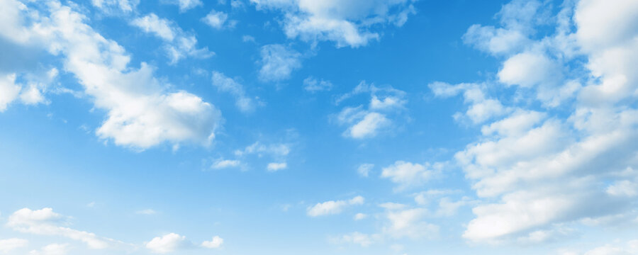 Clear blue sky with scattered fluffy white clouds