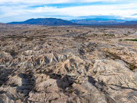 Aerial view of the Tatacoa Desert, specifically the Grey Desert, featuring eroded badlands, dry terrain, and sparse vegetation in Villavieja, Huila, Colombia.