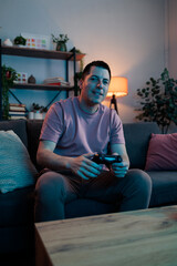 Man enjoying video game playing on sofa © MexChriss