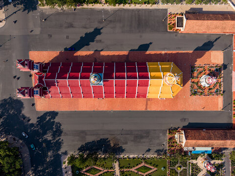 Aerial view of the Tay Ninh Holy See Temple, a vibrant Cao Dai religious site with red and yellow roof, surrounded by courtyards and gardens in Tay Ninh Hoa, Tay Ninh, Vietnam.