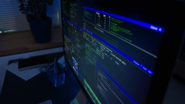 Computer monitor displaying running programming code scripts during cybersecurity data analysis. Perfect for technology advertising and corporate IT security videos