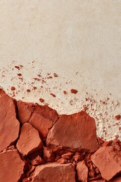 Crumbled red clay plaster fragments on beige wall background for design, poster, texture and detailed closeup