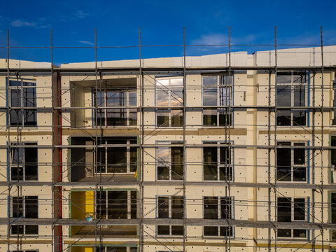 Building facade thermal insulation work with scaffolding on apartment house