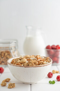 Muesli with fresh raspberries and nuts in a bowl, close-up