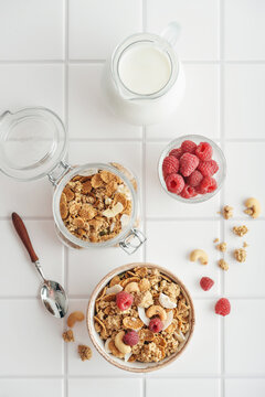 Breakfast ingredients arranged from above on a light tiled background
