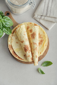 Stack of lavash or chapati flatbreads on a wooden cutting board