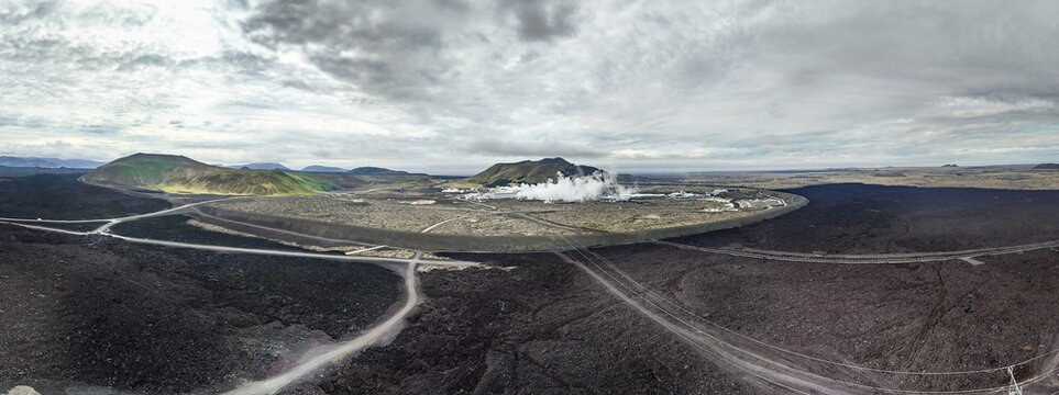Aerial view of the Sundhnukur Volcano area featuring geothermal power plant infrastructure, steam vents, and vast solidified lava fields in Grindavik, Grindavikurbaer, Iceland.