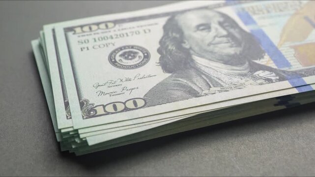 A growing stack of one hundred us dollar bills
