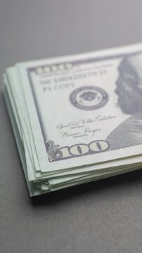 A growing stack of one hundred us dollar bills