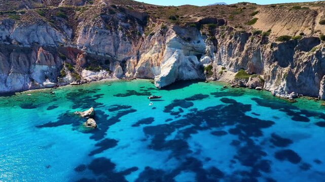 Aerial view of Milos island coastline in Greece, crystal clear turquoise Aegean sea in the Cyclades, vacation on Greek islands, idyllic Mediterranean Sea drone landscape