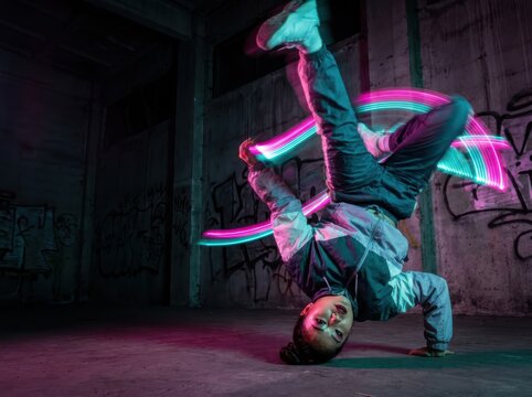 Neon breakdancer in graffiti warehouse with dramatic light trails