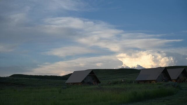 Time lapse of summer storm clouds building behind park tents in a open prairie
