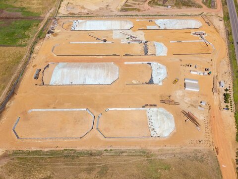Aerial view of an industrial construction site with large excavated basins, earthworks, and storage areas in Philadelphia, Western Cape, South Africa.