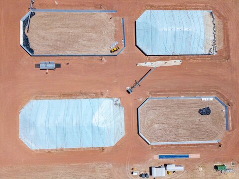 Aerial view of an industrial site with large rectangular basins, some covered with blue tarps and others showing exposed earth, Philadelphia, Western Cape, South Africa.
