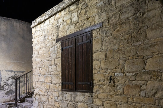 Old stone houses with makeshift wooden shutters on the windows in mountain Omodos village in Cyprus