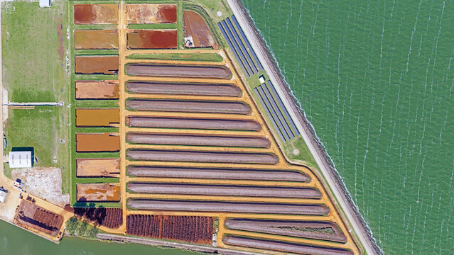 Aerial view of long, parallel waste water basins and sediment ponds at a water purification plant in Andijk, North Holland, Netherlands.