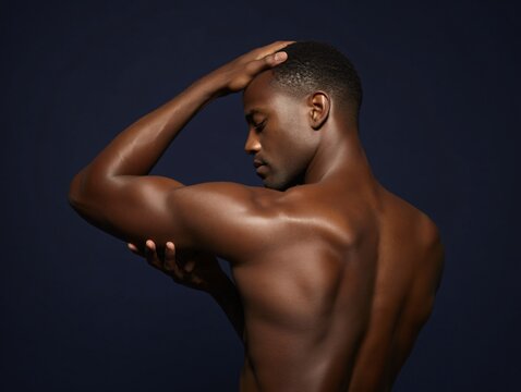 muscular man posing against dark background